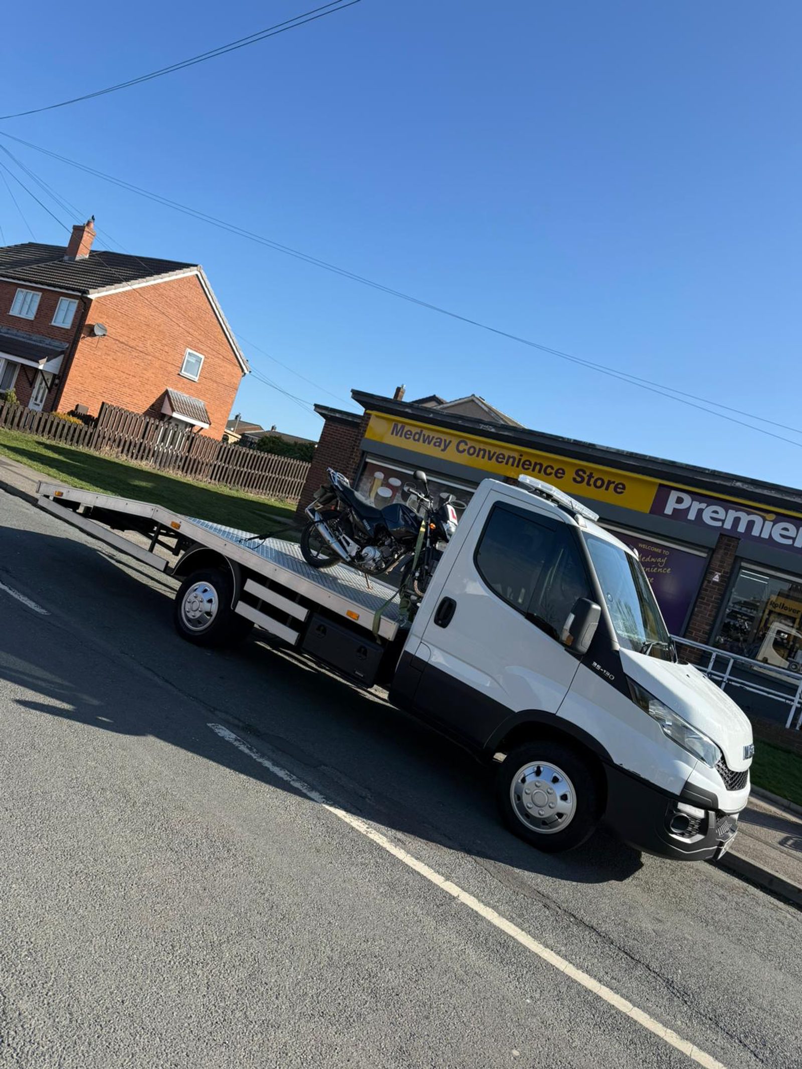 Motorbike strapped down on flatbed in sunshine